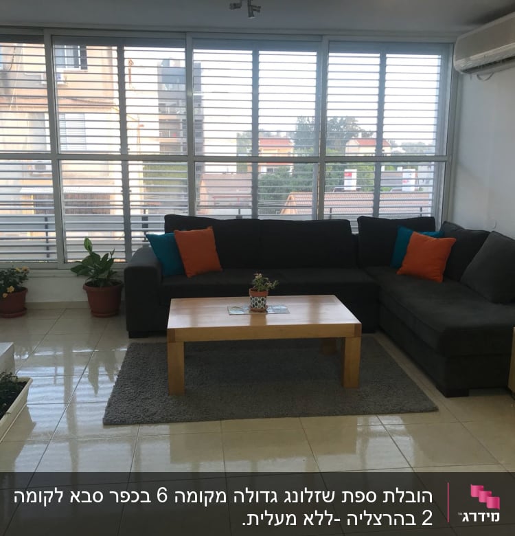 סלון עם ספה, שולחן, עציצים ומזגן על הקיר